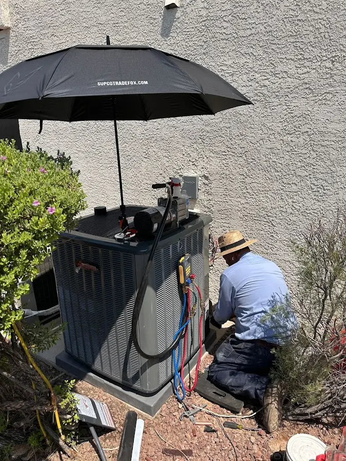 HVAC technician performing outdoor AC maintenance in Commerce